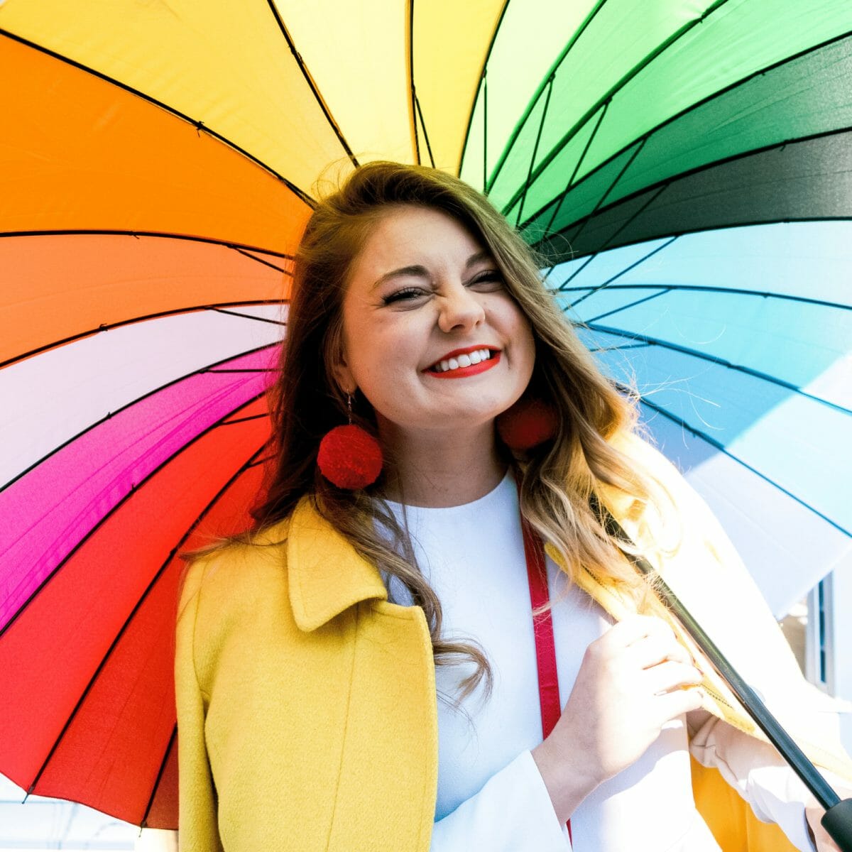 Allie holding a rainbow umbrella